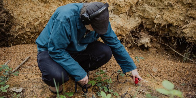 A photo of Jez riley French recording the sounds of the soil in the Forest of Dean. Photo by Camilla Adams.