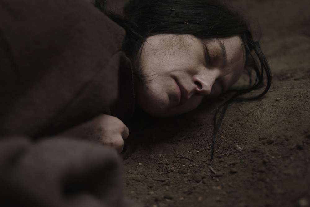 Bog Body - Keeley Forsyth. An image of Keeley lying with her face on the ground.