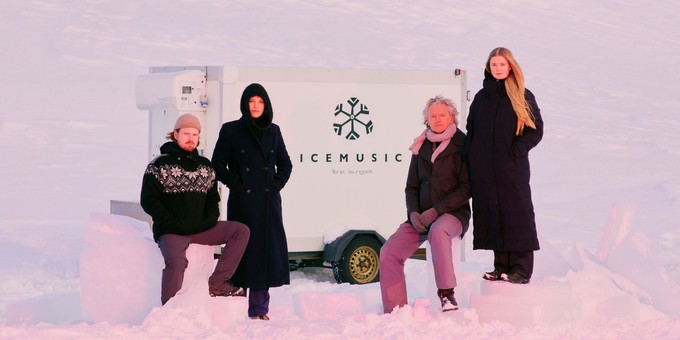 Ice Music Trailer - the quartet stand and sit in front of the trailer surrounded by snow.